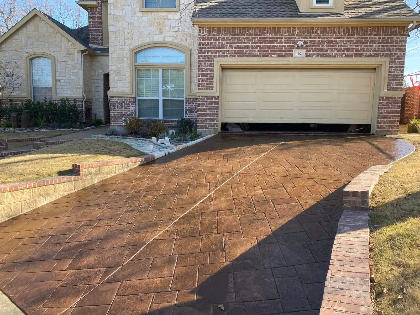 Stamped concrete driveway leading to two-car garage